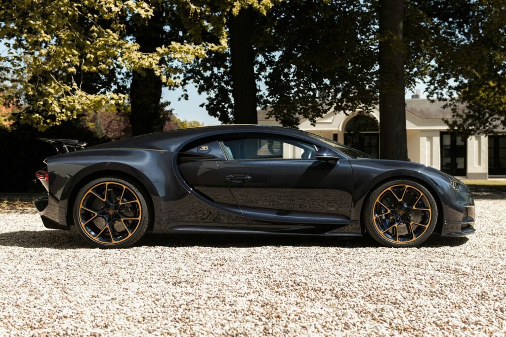 Vista lateral del Bugatti Chiron L’Ébé con líneas decorativas doradas sobre la carrocería en fibra de carbono azul | EUROPA COCHE Y VALLTRO